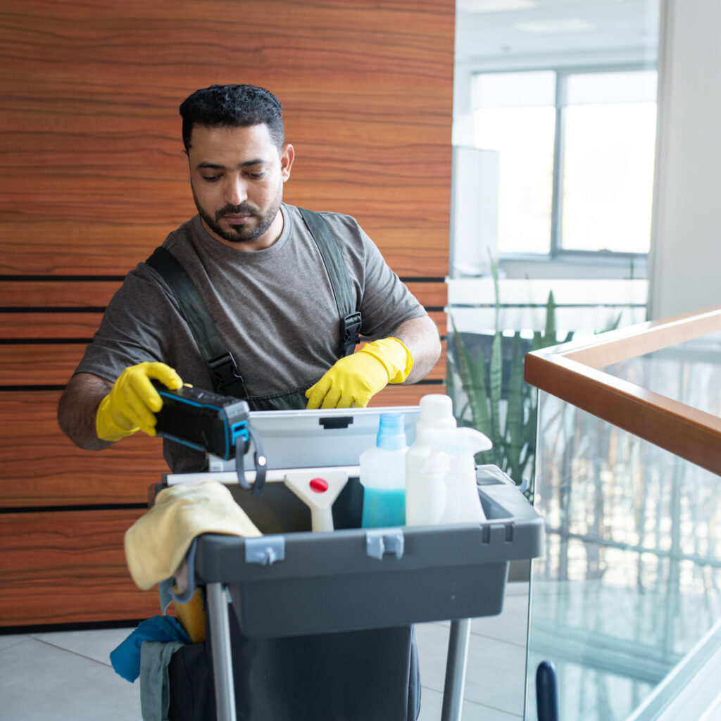 joven trabajando con carrito de limpieza