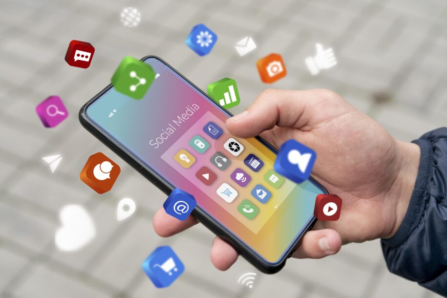 Móvil con iconos de redes sociales y una mano sujetándolo